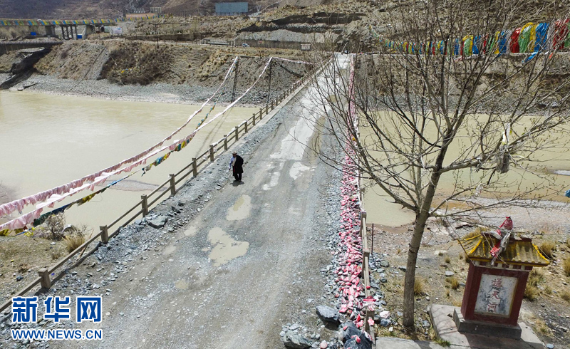 4月22日，尼瑪才讓老人通天河大橋上行走。新華社 吳剛 攝