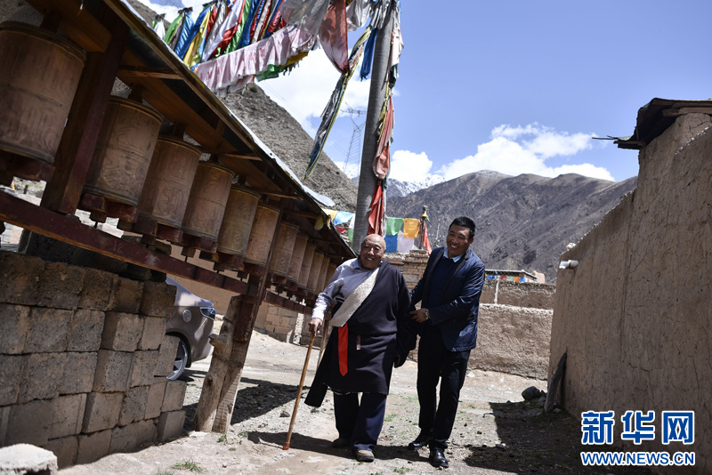 4月22日，陳林巴?。ㄓ遥┡愀赣H尼瑪才讓在村子內(nèi)轉(zhuǎn)寺院。新華社 吳剛 攝