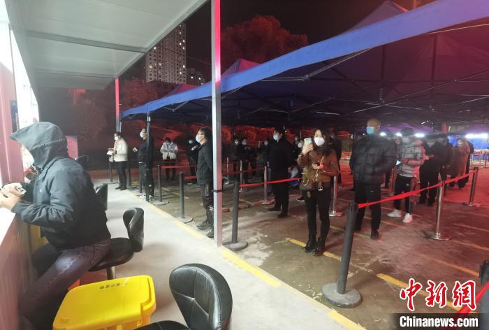 圖為核酸采集窗口前排隊(duì)等候的市民?！∨擞隄?攝