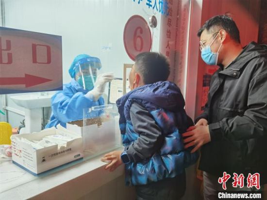 圖為家長帶著孩子進(jìn)行核酸檢測采樣?！∨擞隄崱z