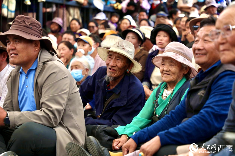 當(dāng)?shù)厝罕姾陀慰陀^看藏戲演出。