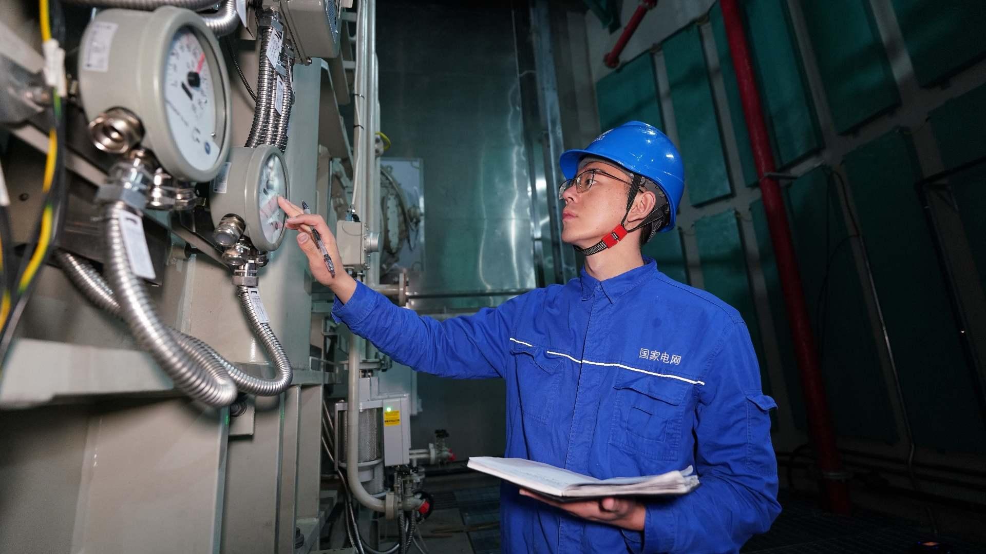 國網(wǎng)四川電力藏族員工次爾杜吉在布拖換流站檢查油表。鄭自豪攝